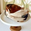 Detail view of tie-dye printed wide knotted headband on a white ceramic tray - Coffee Oil Painting
