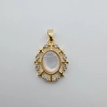 Detail of 18K gold-plated oval shell pendant with zircon star accents and hook - Oval (White Mother of Pearl)