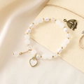 Elegant beaded bracelet featuring white beads, faceted crystals, and a gold heart charm - White Bead Bracelet + Heart (K3510)