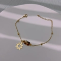 Goldenes Sonnenarmband mit Marmorperlen auf minimalistischem weißem strukturiertem Display - Sonne