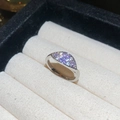 Primer plano de anillo de plata con circonitas moradas y blancas sobre caja de terciopelo - Estilo Hoja Morada Plateado