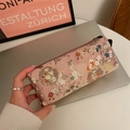 Pink floral embroidery stationery case with zipper closure and side handle shown in hand - Pink