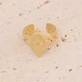 Close-up of gold starburst engraved oval ring on a textured stone surface - Oval Octagonal Star Style (R099-4)