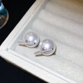 Dettaglio macro di orecchini di perle con barra d'argento e pietre di zircone lucide - Bianco