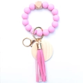 Detail of pink silicone beads, natural wood hex bead, and leather tassel on a key ring - Pink