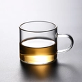 Minimalist heat-resistant borosilicate glass tea cup with handle and clear amber tea - Transparent Handle