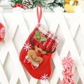 Detail of a red Christmas stocking with reindeer motif hanging on white wooden fence - Bell Reindeer / Small