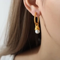 Elegante vergoldete Creolen mit weißem Perlenanhänger am Ohr einer Frau - Mit Muschelperle / Gold