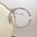 Dettaglio del bracciale rigido argento con perle di zirconi e anelli metallici - Argento