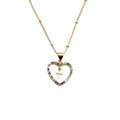 Collana a cuore dorata con gemme colorate e ciondolo a croce interno su sfondo bianco - Cuore Croce / Zirconia Multicolore