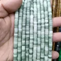 Macro close-up of natural green and white stone rondelle beads for DIY jewelry making - Lushan Jade