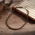Detail of bohemian wood bead necklace with metal clasp on rustic wooden background - Dark Brown Wood Disc (ZJ11065)