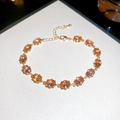 Detail of gold bracelet with fourteen oval-cut champagne zircons and lobster clasp closure - Gold Brown