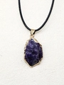 Détail macro du pendentif en pierre naturelle violette avec bord doré et cordon noir - Améthyste