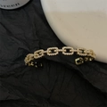 Elegant gold-tone link bracelet with shimmering crystals in a minimalist jewelry display - Gold Chain Link Bangle