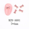 Detail view of 7x4mm gold bow nail charm with pink rhinestones on manicure - A681