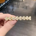 Close-up of gold heart hair clip with sparkling rhinestones held by hand - Gold Heart