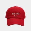 Detailed close-up of white 'NEW YORK N.Y.' embroidery on a red cotton baseball cap - Red