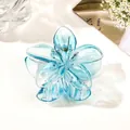 Macro shot of light blue floral claw clip with transparent gradient resin finish - Transparent Blue