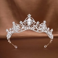 Elegant silver bridal tiara featuring clear crystals and marquise gemstones on brown satin - Silver