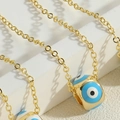 Goldene O-Kettenhalskette mit blauem Emaille-Augen-Anhänger auf weißen Stufen - Blau