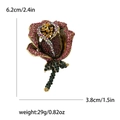 Spilla rosa elegante con strass rossi e base dorata per completi da donna - Viola