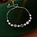 Macro shot of silver zircon flower bracelet with colorful stones on green velvet - Silver Round Colorful Gemstone Style