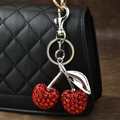 Sparkling red crystal cherry keychain with silver leaves on a black leather handbag - Rhinestone Cherry Silver Leaf Red