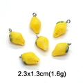 Detail of yellow lemon charms for DIY jewelry with dimensions 2.3x1.3cm and green leaf - Iridescent Lemon