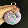 Détail du porte-clés pompon violet avec lettre O en résine et fermoir doré - Lettre O