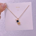 Dettaglio della collana con coniglio astronauta oro e gemma stellata blu su carta - Coniglio Spaziale (XK0011)