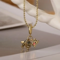 Gouden kralenketting met vliegtuig- en wereldbolhangers op neutrale achtergrond - Vliegtuig Aarde Paspoort Stijl