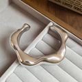 Detailed view of an irregular wavy silver open cuff bracelet on a velvet display tray - Bracelet-Silver-Irregular