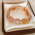 Detail of rose gold bracelet with colorful cubic zirconia on cream satin cushion - Rose Gold Multi-color