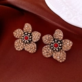 Macro shot of vintage crystal flower earrings on luxury silk with gold petals - Antique Gold with Champagne Zirconia