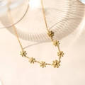 Collana in acciaio al titanio placcata oro 18K con sette ciondoli a margherita su catena fine - Collana margherita oro