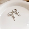 Macro view of silver bow earrings with tassels and rhinestones on ceramic tray - Silver Rhinestone Bow Earring Buckle (12# Silver Needle)