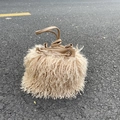 Close-up of beige faux sheep fur bucket bag with leather drawstring and handles outdoor - Milk Coffee
