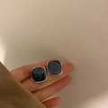 Orecchini a perno quadrati dorati con intarsio in marmo grigio scuro tenuti in mano - No.29 Perno in Argento - Blu Nebbia