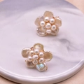 Elegant natural pearl flower earrings with golden metal base on white marble background - White Baroque Pearl Flower Studs