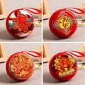 Macro shot of four red festive tinplate coin purses with traditional Chinese New Year patterns - Round Chinese New Year Style