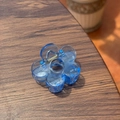 Détail d'une pince à cheveux fleur bleue translucide sur une surface en bois foncé - 5cm / Bleu Royal
