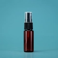 Empty brown plastic spray bottle with black pump and clear cap on blue background - 20ml / Amber Bottle Black Spray