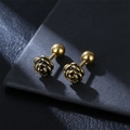 Golden rose stud earrings with black enamel detail on textured black leather background - Single Piece / Gold Small