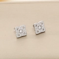 Détail macro de boucles d'oreilles cœur en argent avec zircons sur boîte beige - Boucles d'Oreilles Clous Fleur Géométrique Zirconia Blanc Couleur Acier 10mm (KE109784-KLX)