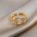 Detailed shot of golden heart-shaped rhinestone ring with chain band on silk - Circular Heart