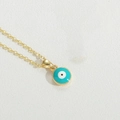 Golden necklace with turquoise evil eye pendant on white leather background - Lake Blue