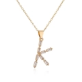 Macro view of 18K gold plated letter K pendant with sparkling zircon gemstones - Letter K