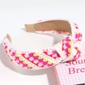 Detail of pink and yellow knitted headband with knotted design and floral embroidery texture - Rose Pink Yellow Striped Knotted