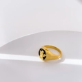 Macro detail of gold signet ring with black oval face and angel relief engraving - Angel Carving